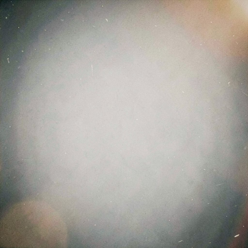 Analog film photograph of a dark training course and pale blue sky, with visible grain and a focused, determined mood